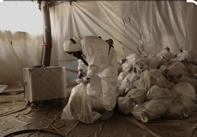 Professional asbestos removal specialist working on a garage roof in Surrey